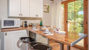 Una cucina con mobili bianchi, un forno a microonde, un tostapane e un tavolo da pranzo con sedie.
