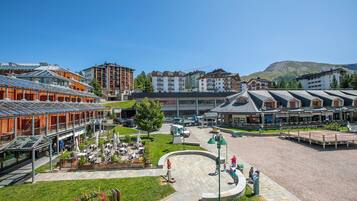 A hotel with a central courtyard, outdoor seating, and a view of surrounding buildings.