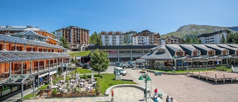 Un hotel con patio central, mobiliario exterior y vistas de los edificios circundantes.