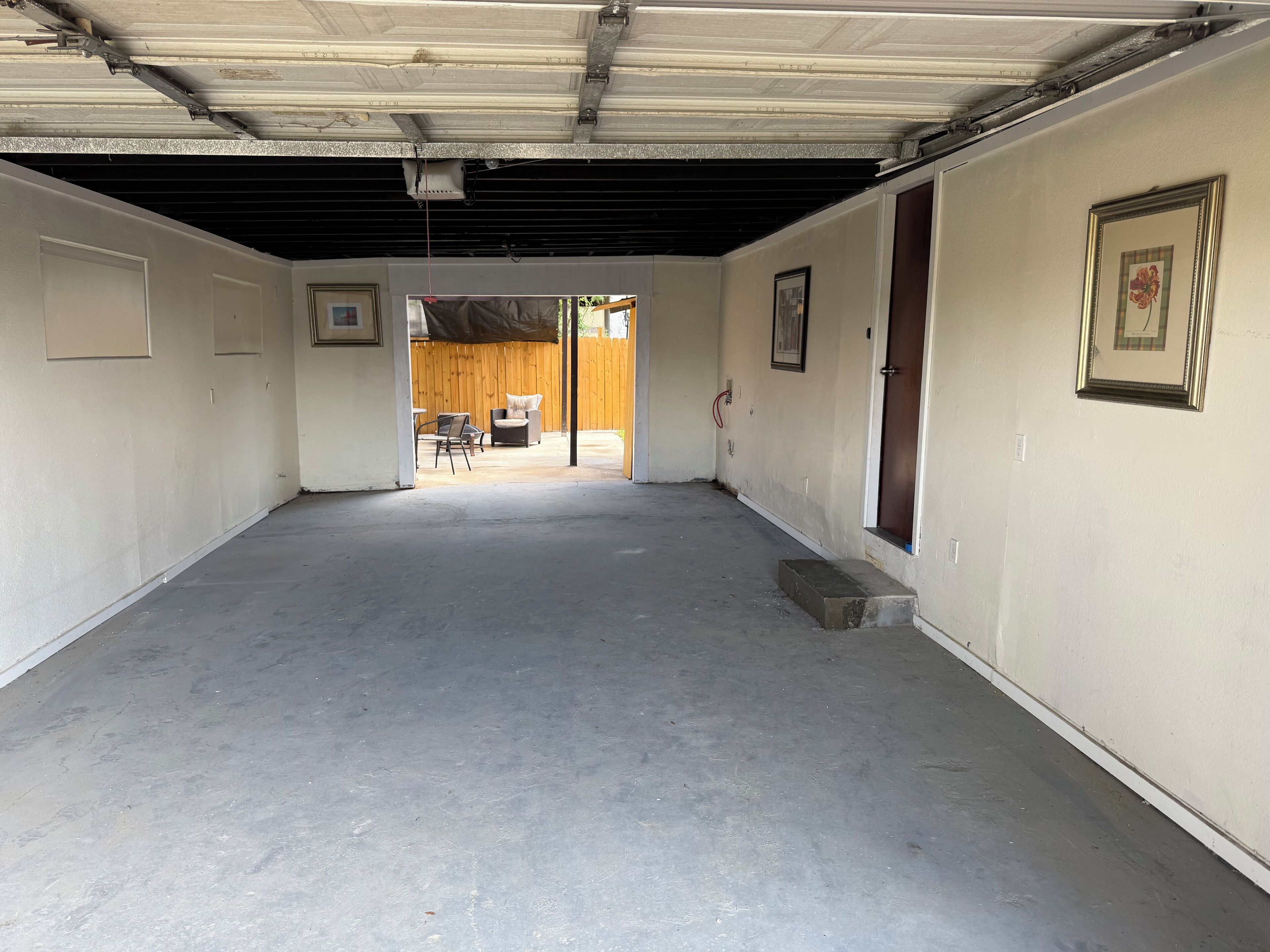 An empty room with a concrete floor, a wooden door, and a window.