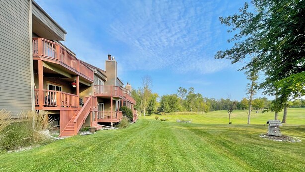A two-story house with a red balcony and a well-maintained lawn. - Lakeside golf Retreat • Views • ATV Trails & Pool (Hill City)