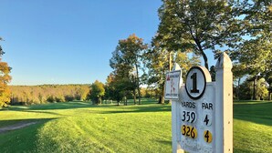 A golf course sign with distance markers and a hazard warning. - Lakeside golf Retreat • Views • ATV Trails & Pool (Hill City)