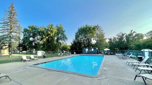 A rectangular swimming pool with lounge chairs and a small building in the background. - Lakeside golf Retreat • Views • ATV Trails & Pool (Hill City)
