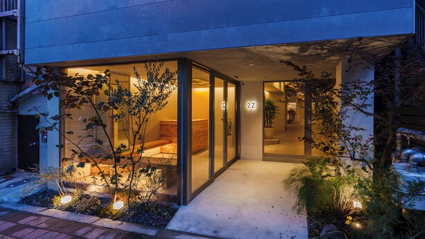 A modern building with a glass entrance, a visible number '22', and outdoor plants. - 2Z - DOYANEN HOTELS (Osaka)