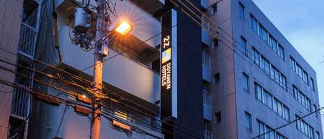 A multi-story building with a prominent sign indicating it is a hotel.