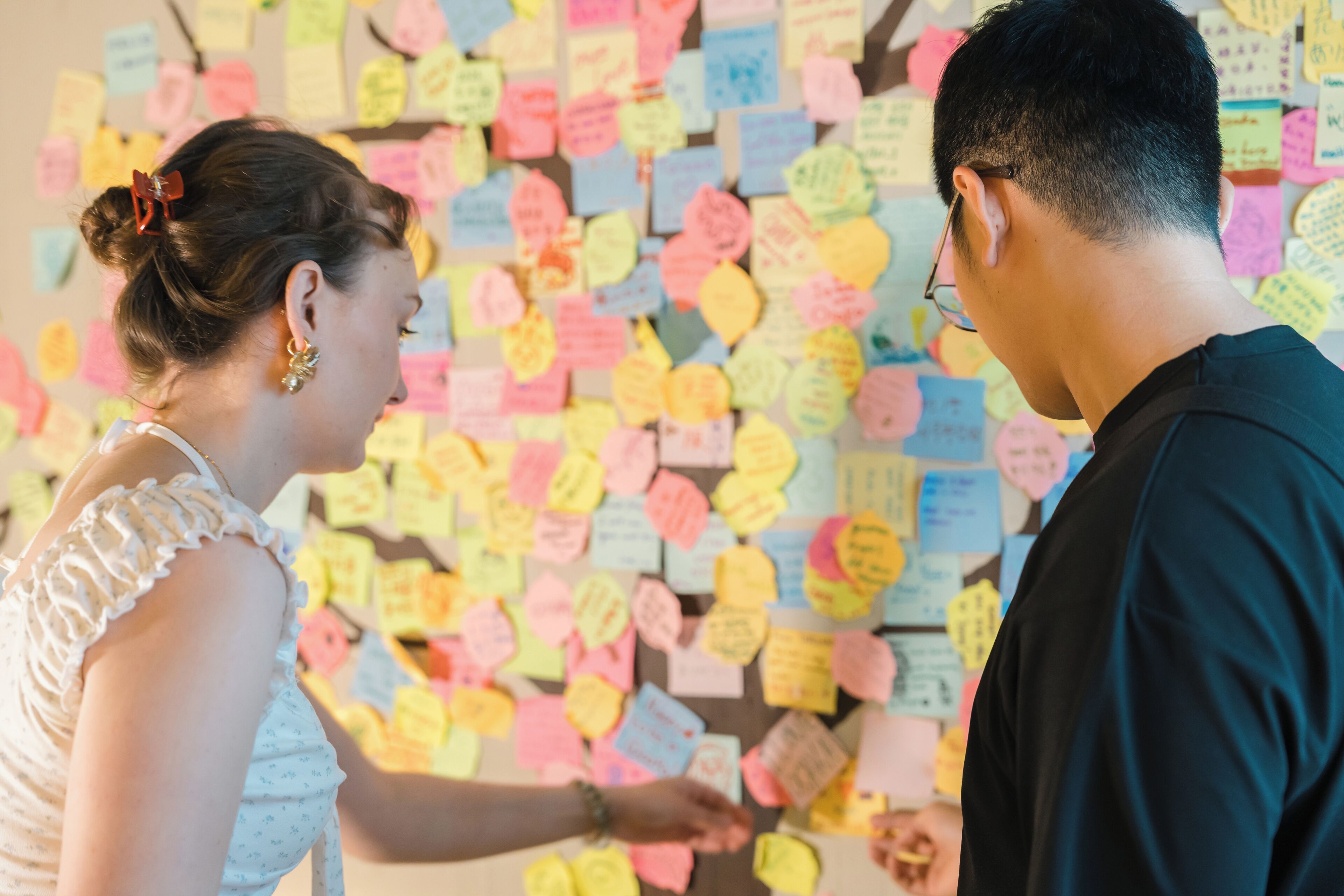 A room with a wall covered in colorful sticky notes.