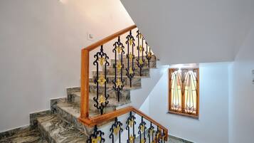 Una escalera con escalones de mármol y barandillas de hierro forjado en amarillo y negro.