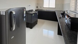 Een moderne keuken met een koelkast, wasmachine en fornuis.