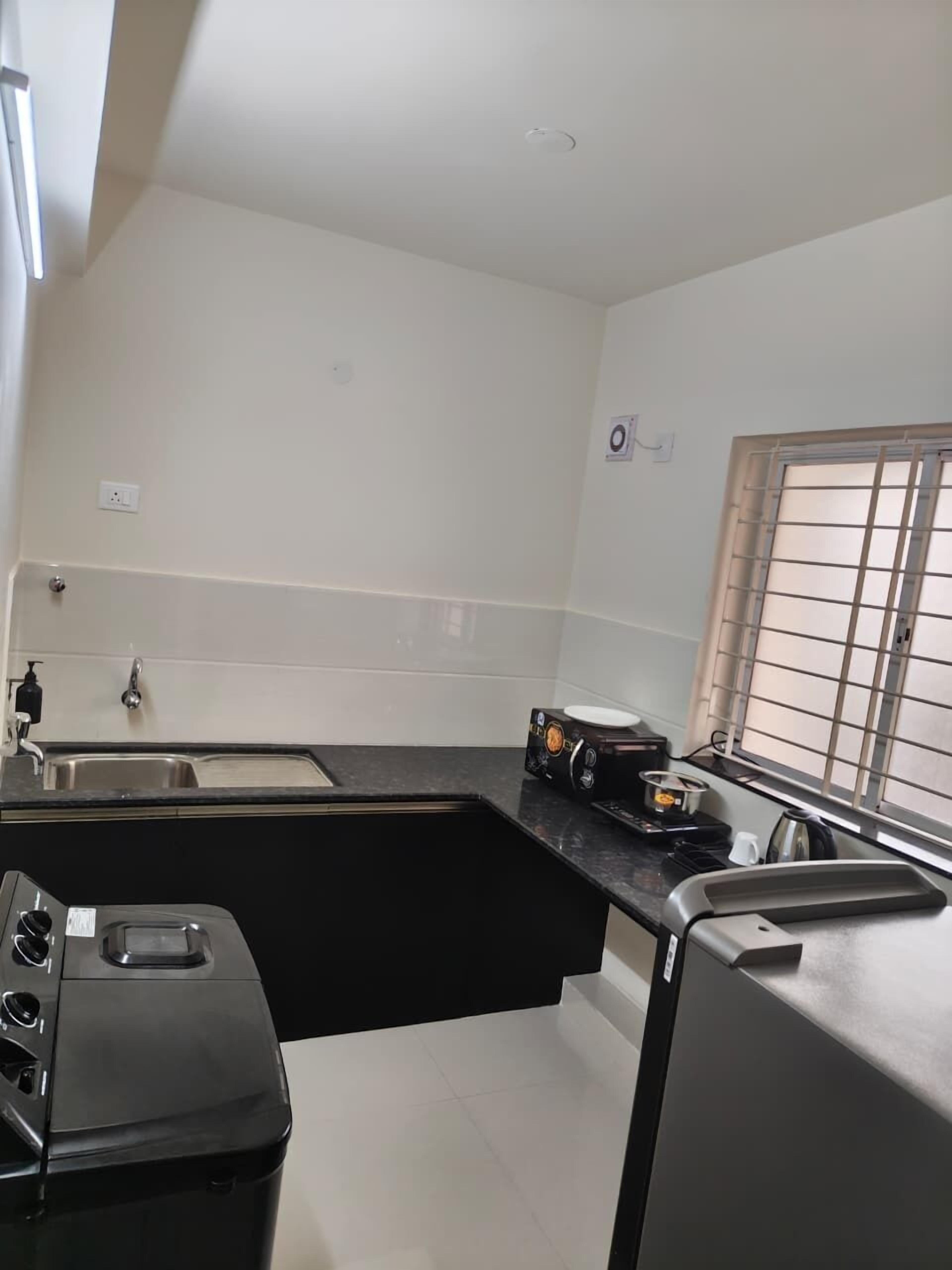 A compact kitchen with a sink, stove, and window.