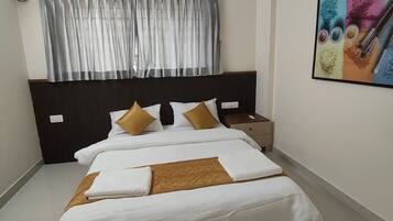 A neatly made bed with white and brown linens, a dark headboard, and a ceiling fan.