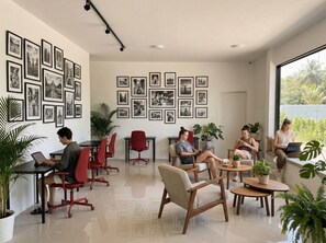 Ein modernes Büro mit mehreren Arbeitsplätzen, gerahmten Bildern an den Wänden und Zimmerpflanzen.