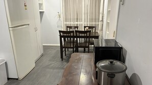 A compact kitchen with a refrigerator, a stove, a dining table with chairs, and a window with sheer curtains. - Three furnished bedrooms and two bathrooms house (Deer park)