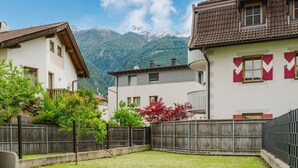 Ein Wohngebiet mit Häusern, einem Holzzaun und einem Berg im Hintergrund.
