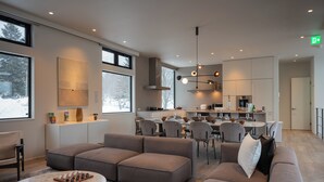 A modern interior with a dining area, kitchen, and seating. - Mokuren by H2 Life (Niseko)
