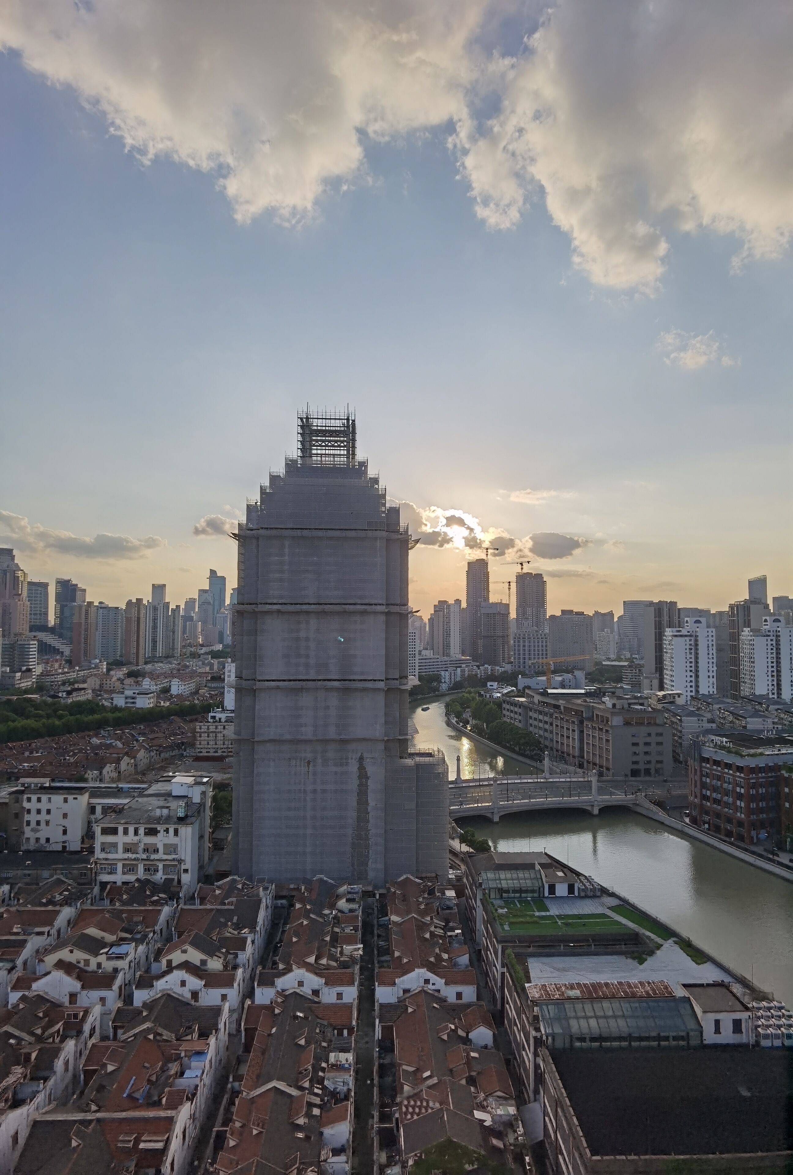 Un grattacielo dal design originale a gradoni, circondato da un fiume e da un panorama urbano con diversi edifici.