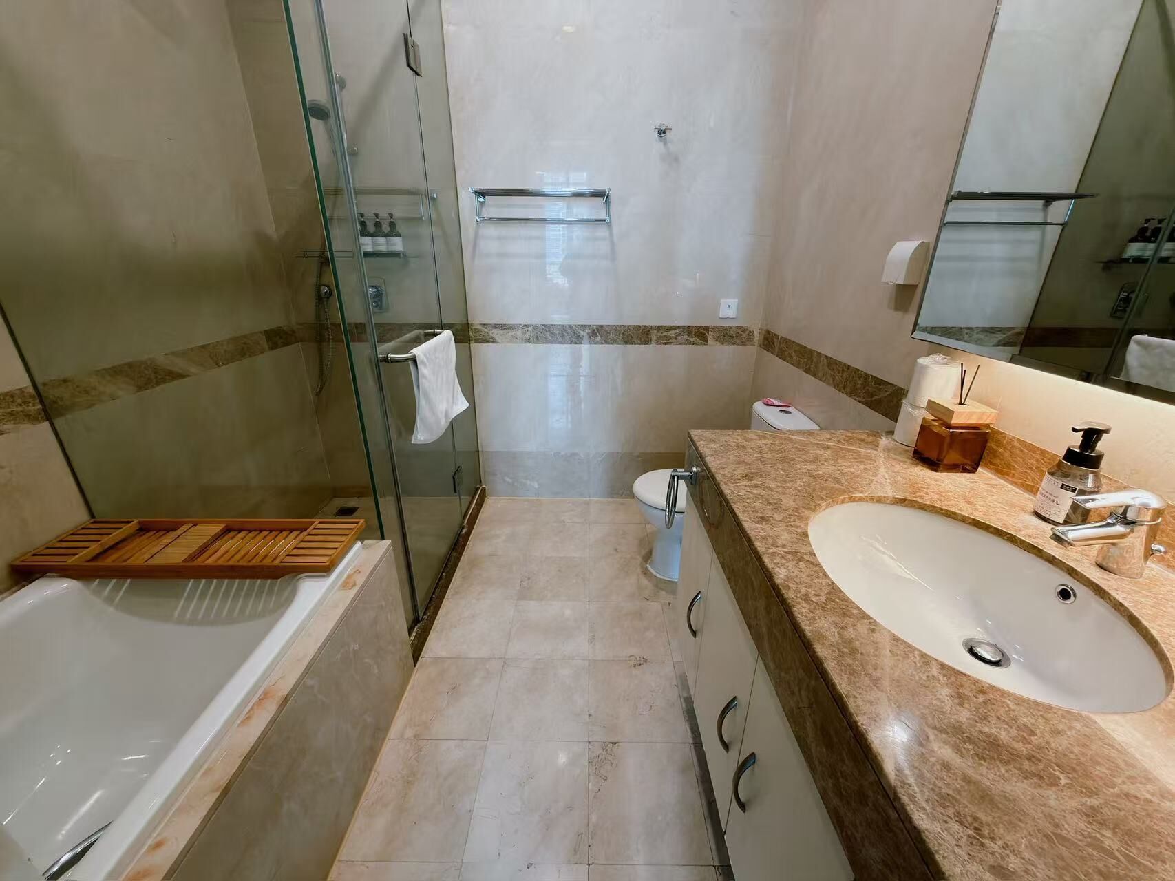 A bathroom with a bathtub, a sink, a toilet, and a glass shower enclosure.