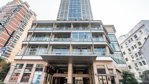 A multi-story building with a modern architectural design, featuring a prominent entrance with a covered area and multiple balconies. - River House Near Peoples Square And The Bund (Shanghai)