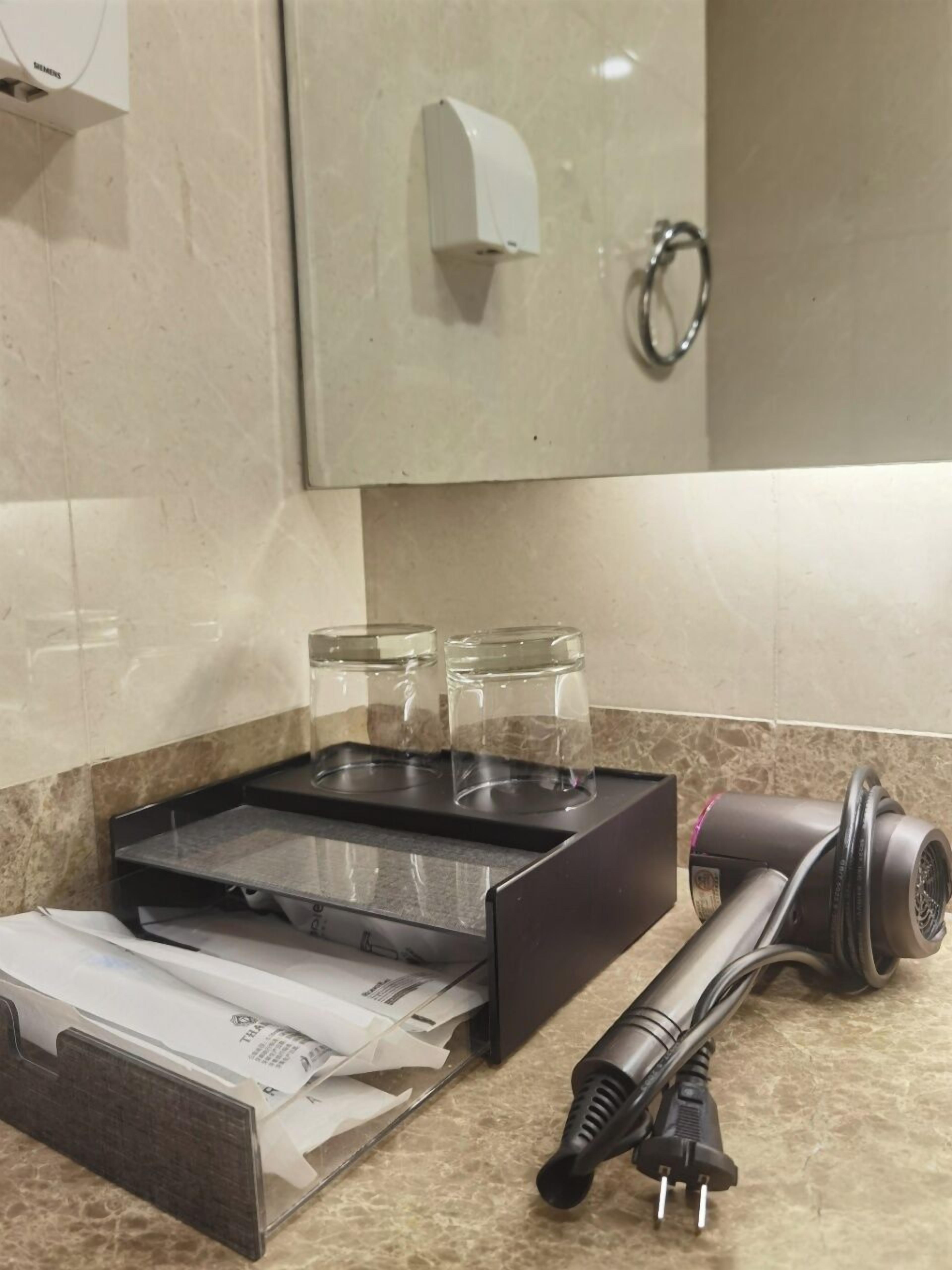 A kitchen counter with a coffee machine, a paper towel dispenser, and two glass jars.