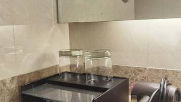 A kitchen counter with a coffee machine, a paper towel dispenser, and two glass jars.