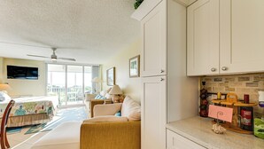 A compact living space with a kitchenette, a dining area, and a balcony with a view. - Oceanfront Studio w/ Gulf & Sunset Views From Bed! (Naples)