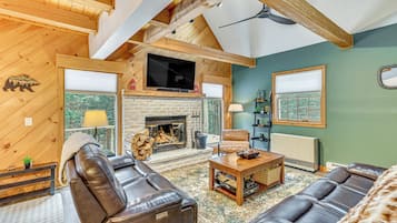 A cozy living room with a fireplace, leather sofas, and a television.