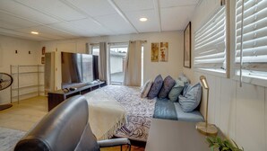 A bedroom with a bed, a desk, a chair, a TV, and a window with blinds. - 5 Mi to Dtwn Riverside & Hospital! Remote-Work Hub (Riverside)