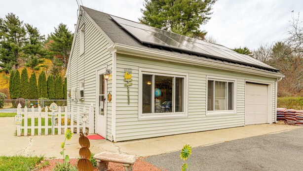 A small, single-story building with a sloped roof, a front porch, and a garage. - Hike & Explore Western Mass: Peaceful Studio (Palmer)