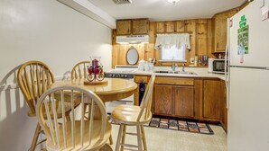 A kitchen with wooden cabinets, a stove, a sink, and a refrigerator. - Hike & Explore Western Mass: Peaceful Studio (Palmer)