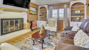 A living room with a fireplace, a television, a bookshelf, and a comfortable seating area. - River, Trails & Wine! Extended Escape Near Mt Airy (Ararat)