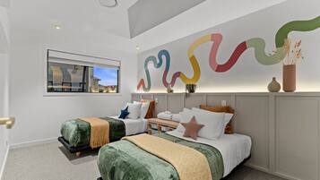A modern hotel room with two beds, a large abstract wall art piece, a window with a view, and a ceiling light.