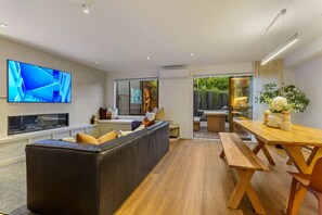 TV, fireplace, books - Spacious Coastal Luxe Home with Sea View & Parking (Auckland Hibiscus Coast)