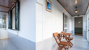 Ein Korridor mit einem Holztisch, Stühlen, einem gerahmten Bild an der Wand und einer Deckenleuchte.