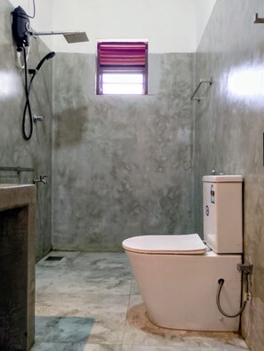 A bathroom with a toilet, a shower, and a window. - Crush River Villa Hikkaduwa (Hikkaduwa)