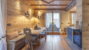 A wooden interior with a dining area, bench seating, and a kitchen area. - Casa Maddalena, comfort in Cortina d'Ampezzo (Cortina d´Ampezzo)