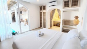 A hotel room with a large bed, a bathroom with a shower, and a view of the outdoor area. - Villa Vinodayan Uluwatu (Ungasan)