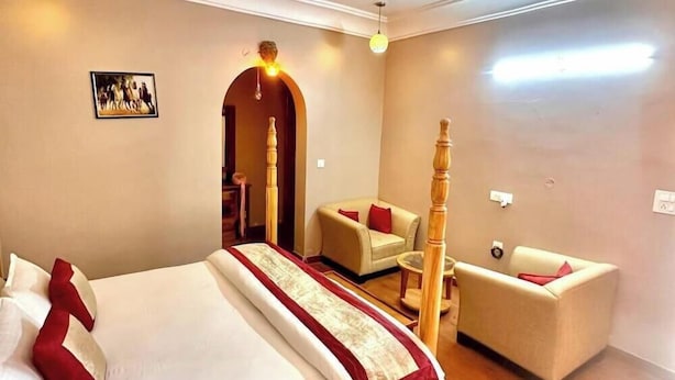 A hotel room with a bed, a chair, and a sofa. - Nimbal Dhani (Jaipur)