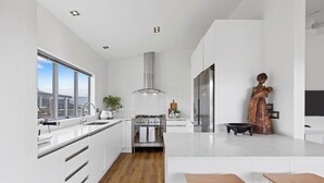 Una cocina moderna con una isla grande, electrodomésticos de acero inoxidable y vistas a la ciudad.