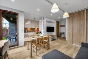 Um apartamento moderno com área de jantar, cozinha e sala de estar.