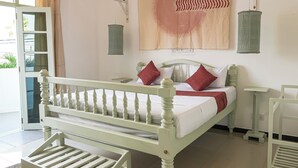 A bed with a white headboard and footboard, a bedside table, and a wall-mounted lamp. - Mira Mirissa  (Mirissa)
