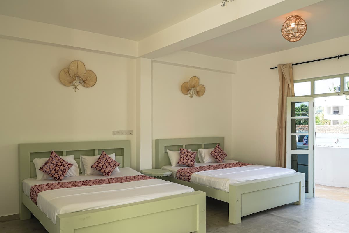 A hotel room with two beds, a large window with a view, and a ceiling fan.