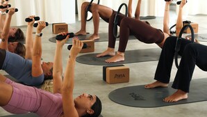 A group of people performing an exercise with dumbbells and resistance bands in a room with yoga mats and MIRAI branded boxes. - Mira Mirissa  (Mirissa)