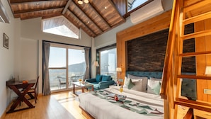 A spacious bedroom with a large bed, a wooden ceiling, and a view of the city. - Moustache Select Mcleodganj (Dharamshala)