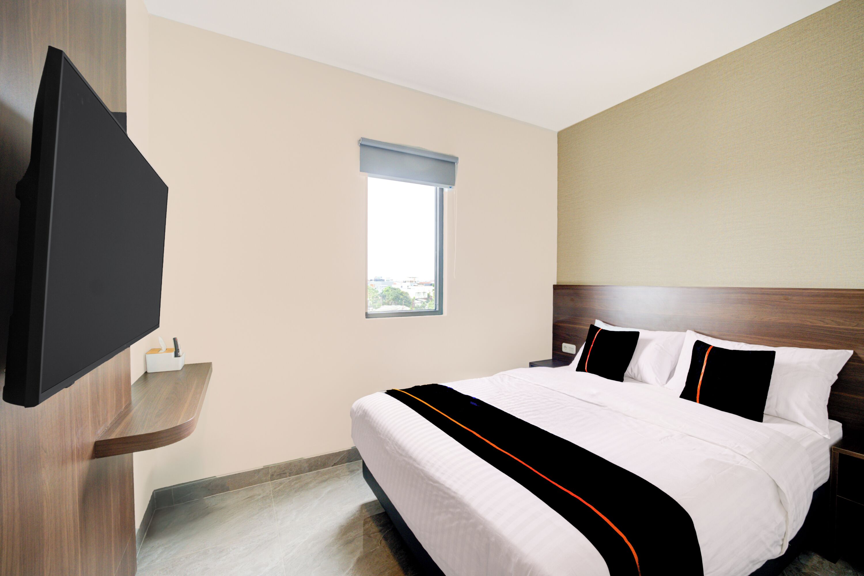 Habitación de hotel con cama, televisión de pantalla plana montada en la pared, ventana y cabecero de madera.
