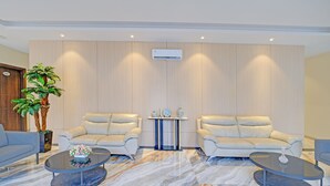 Een moderne woonkamer met twee banken, een bijzettafeltje en een potplant.
