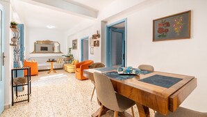 Un comedor con una mesa de madera, sillas y una cocina al fondo.