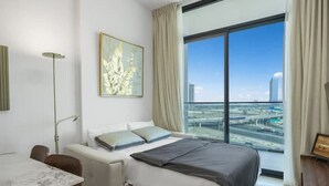 Een moderne hotelkamer met een groot bed, een bureau en uitzicht op de stad.