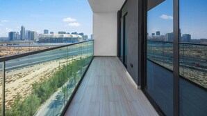 Een balkon met uitzicht op de stad, met moderne gebouwen en een snelweg.