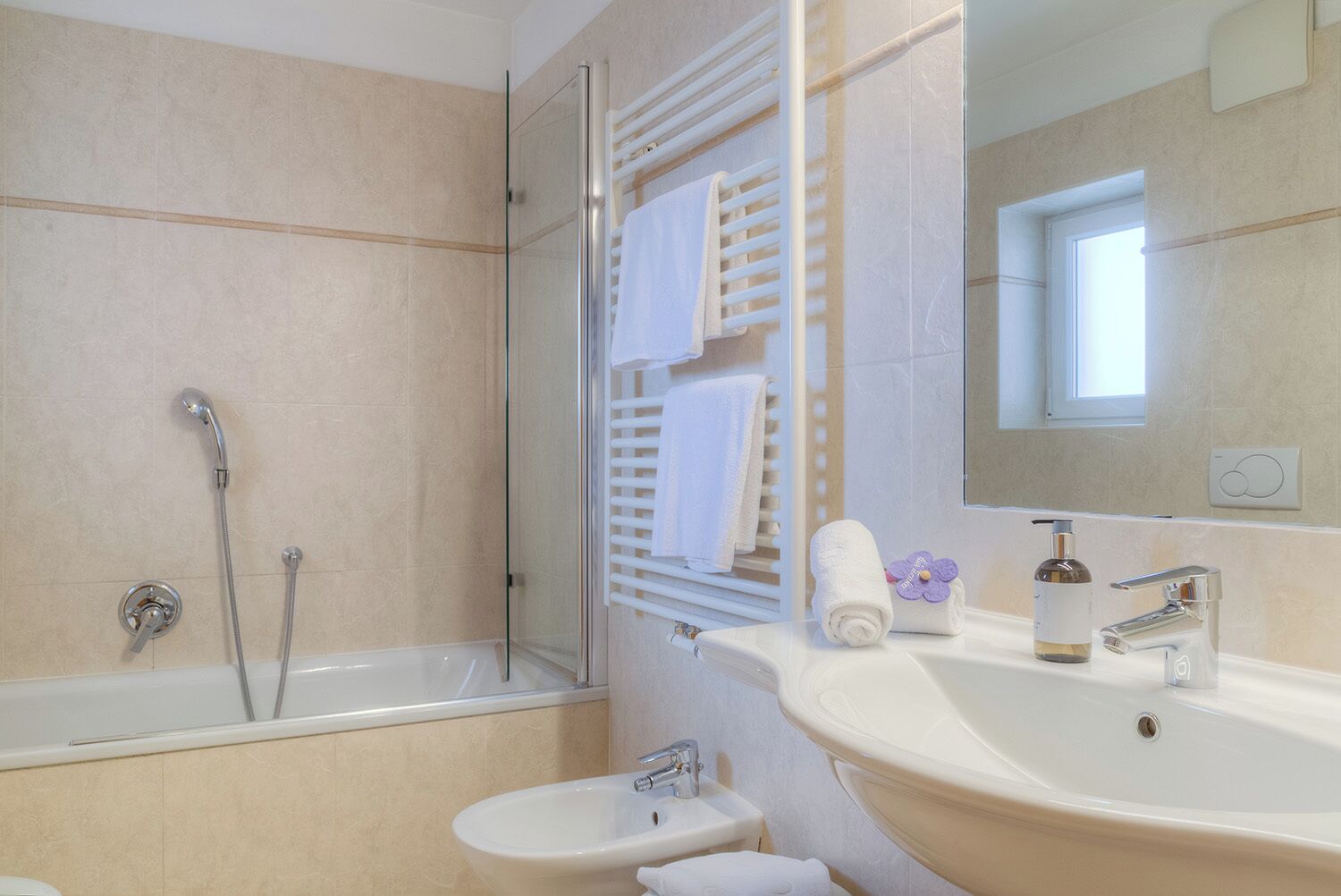 A modern bathroom with a bathtub, shower, and sink.