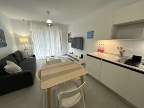 Een moderne woonkamer met een bank, een eettafel en een televisie.