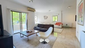 Een moderne woonkamer met een bank, een salontafel en een televisie.